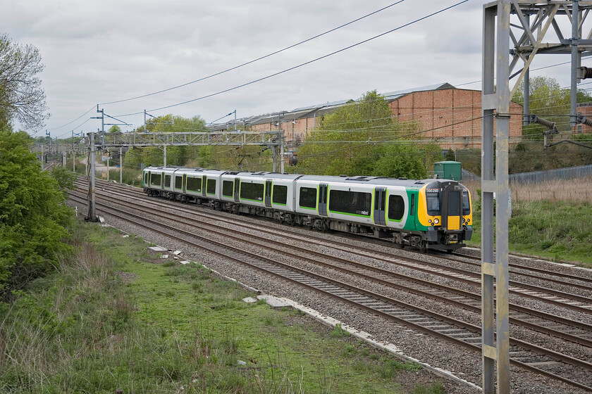 350250, LM 16.14 Birmingham New Street-London Euston, Roade 
 The 16.14 Birmingham New Street to Euston London Midland service, worked by 350250, accelerates past Roade, having just exited Roade cutting. This wide-angle view clearly shows the former Pianoforte factory that was rail-connected with the tracks diverging from the slow lines about level with the front of the train. 
 Keywords: 350250 16.14 Birmingham New Street-London Euston Roade London Midland Desiro