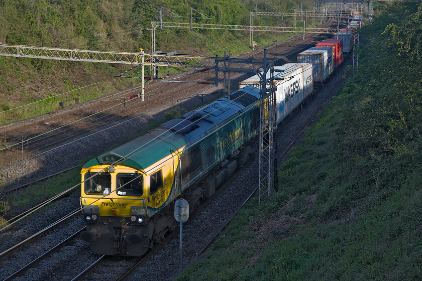 666418, 05.00 Crewe BH-Felixstowe North (4L89, RT), Victoria bridge 
 66518 Patriot In Memory of Fallen Railway Employees just catches some early morning sunlight as it passes Victoria bridge south of Roade leading the 05.00 Crewe Basford Hall to Felixstowe Freightliner. This was the first of a procession of freights within half an hour or so a situation partially created by diversions as a result of the Nuneham viaduct closure in Oxfordshire. 
 Keywords: 666418 05.00 Crewe BH-Felixstowe North 4L89 Victoria bridge Freightliner Patriot In Memory of Fallen Railway Employees