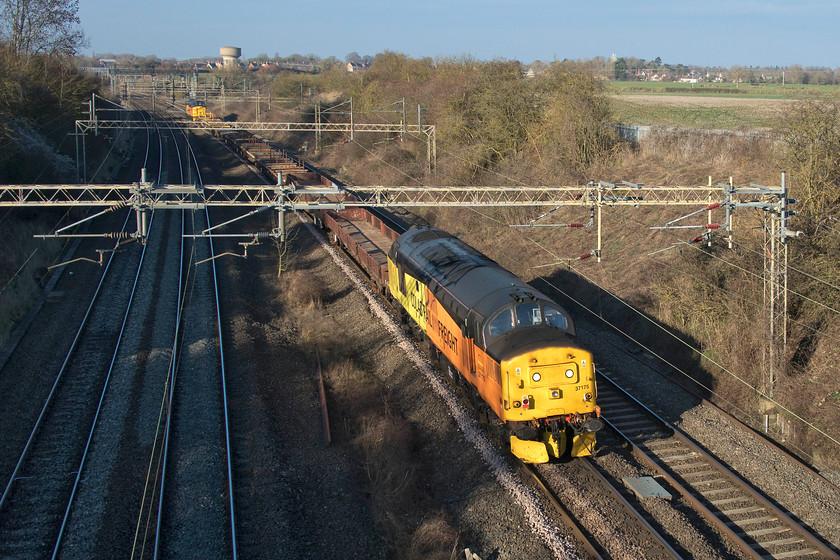 37175 & 37219, 10.57 Willesden-Crewe Basford Hall (6C37), Victoria bridge 
 Dead in tow, 37175 is seen at the back of the 10.57 Willesden to Crewe Basford Hall infrastructure working of track wagons. 37175 'Shirley Ann Smith' is doing all the work at the front. Notice how the blue sky from earlier has been covered by a lot of dark cloud as a very pronounced cold front heads down from the north west spoiling the rest of the afternoon. 
 Keywords: 37175 37219 10.57 Willesden-Crewe Basford Hall 6C37 Victoria bridge