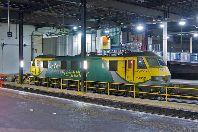 90049, stabled Thunderbird, London Euston station 
 On hire from Freightliner for Thunderbird duties, 90049 sits on the blocks at London Euston. This photograph further illustrates what a dreary station Euston is particularly at night. I hope that when (if?) the HS2 works begin that something far more fitting and grand is built rather like the approach taken to the re-building of St. Pancras and neighbouring King's Cross. 
 Keywords: 90049 Thunderbird London Euston station