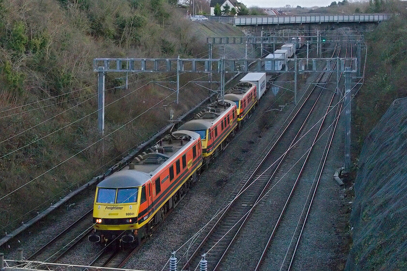 90041, 90013 & 90004, 09.32 Felixstowe North-Ditton (4M88, 4E), Hyde Road bridge 
 With potentially fifteen thousand horsepower on tap, the 4M88 09.32 Felixstowe to Ditton passes Roade. However, close examination reveals that 90004 (the third locomotive in the lineup) has its pantograph lowered with just 90041 and 90013 under power. It could have been failure that caused this event but as the train was running to time suggests that this was not the case. Perhaps 90004 was simply being returned to Freightliner's Crewe headquarters with the train having over an hour timetabled stop at Basford Hall giving ample time to remove it from the consist. Incidentally, since it was named on 13.09.24 this is my first photograph of 90041 'Pete Waterman OBE'. 
 Keywords: 90041 90013 90004 09.32 Felixstowe North-Ditton 4M88 Hyde Road bridge Freightliner Pete Waterman OBE