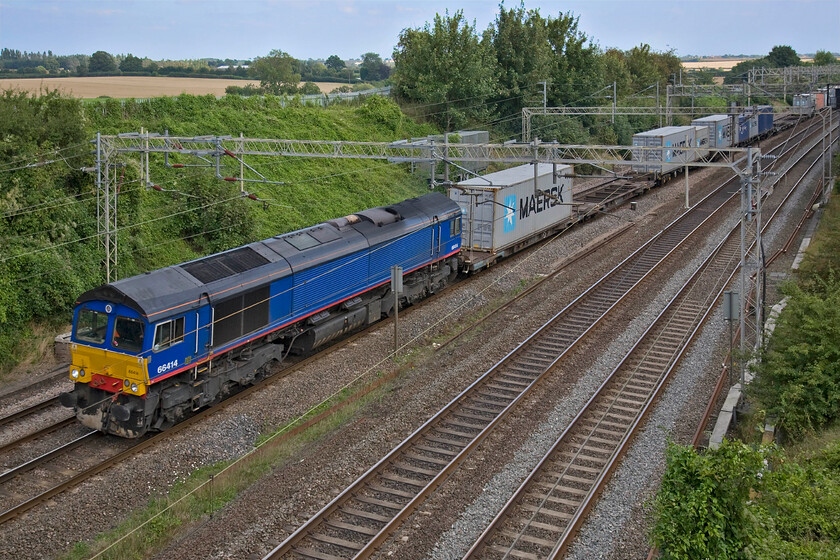 66414, 11.13 Felixstowe North-Trafford Park (4M87), Victoria bridge 
 Now looking a little strange in its de-branded and defunct Stobart livery 66414 works the 11.13 Felixstowe to Trafford Park 4M87 Freightliner service. The train is seen passing Victoria bridge just south of Roade in Northamptonshire in full shade despite the clear blue sky in the background! 
 Keywords: 66414, 11.13 Felixstowe North-Trafford Park (4M87), Victoria bridge