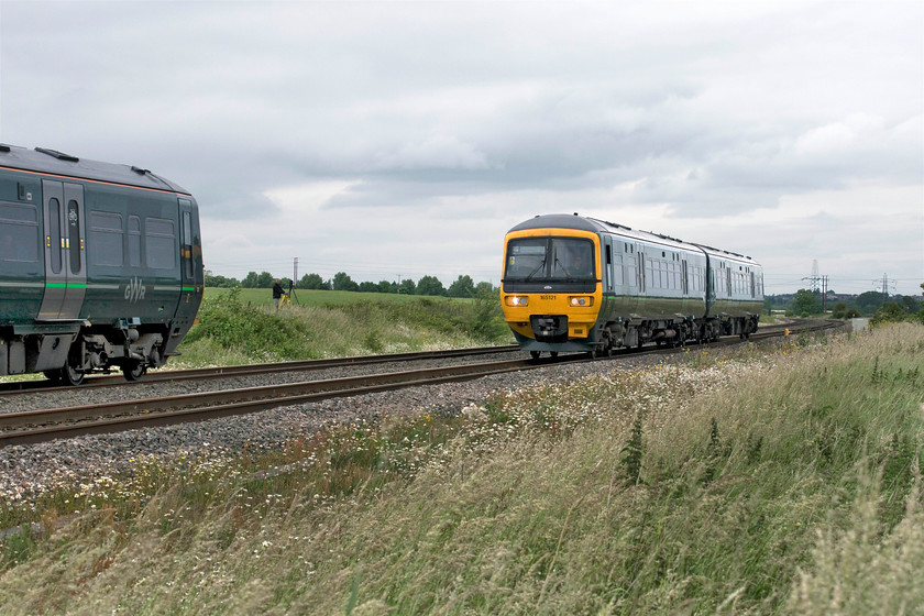 165130, GW 12.31 Didcot Parkway-Oxford (2L30, RT) & 165121, GW 12.36 Oxford-Didcot Parkway (2L33, 1L), Radley SP527002 
 A coming together of Great Western units just north of Radley in Oxfordshire. Under leaden skies, 165130 is working the 12.31 Didcot to Oxford whilst, to the right, 165121 is working the 12.36 Oxford to Didcot. Both these services cover the ten-mile journey, stopping at all three intermediate stations, in just over fifteen minutes. Notice the photographer on his ladder the other side of the line waiting for the passing of 7029 'Clun Castle'. 
 Keywords: 165130 12.31 Didcot Parkway-Oxford 2L30 165121 12.36 Oxford-Didcot Parkway 2L33 Radley SP527002