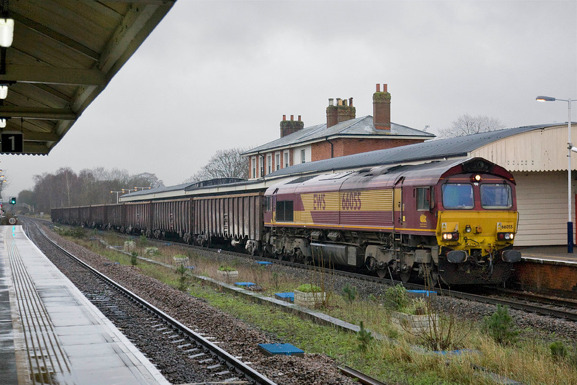 66055, 01.53 Briggs Sidings-Southampton Up Yard (6Z16), Andover station 
 In such dull, dreary and wet weather I had to push the camera a little in order to capture 66055 passing at some speed through Andover station. It is seen leading the 01.53 Briggs Sidings (Peak District) to Southampton Up yard sone train. This 6Z16 working has travelled through the night and is now relatively close to its destination. 
 Keywords: 66055 01.53 Briggs Sidings-Southampton Up Yard 6Z16 Andover station EWS