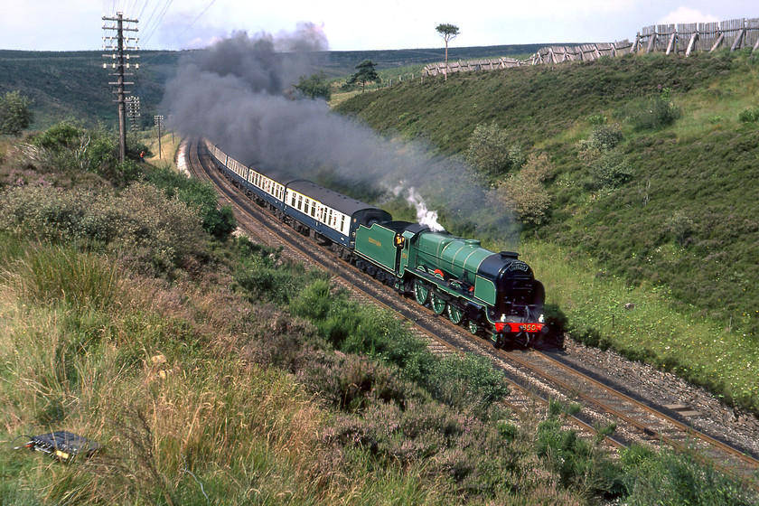 850, outward leg of Cumbrian Mountain Express, Carlisle-Skipton, Dent SD763878 
 At last, some sunshine! A second photo stop with water also being taken on at Garsdale enabled us to get past 850 again after seeing it at Ais Gill. Passing Garsdale made us realise how popular this BR operated charter was with hundreds of cars parked around the station with even more photographers in attendance! We managed to pilot the Austin 1100 to Dent where we walked a little north of the station towards Rise Hill tunnel that is out of view in this photograph behind 850's exhaust. Lord Nelson leads the outward leg of The Cumbrian Mountain Express on the gentle downgrade to its destination trailing a uniform set of Mk. I stock. Today, this view is all but impossible due to the embankment being heavily overgrown and the fells in the background being forested. Notice Graham's Sony TC-153SD cassette deck lying in the grass to the bottom left of the photograph. This was the one that I aspired to as it had Dolby but was double the size and weight on my own new TC-525 unit. I visited exactly the same spot some seven months later in not such great weather but the motive power was pretty impressive, see..... https://www.ontheupfast.com/p/21936chg/30022686221/x46229-cumbrian-mountain-express.

There is an audio recording of this event on my youtube channel, see...https://youtu.be/ffyAo-w7eqE 
 Keywords: 30850 Lord nelson Maunsell 850 Cumbrian Mountain Express Carlisle-Skipton Dent S & C Settle and Carlisle The long drag SD763878