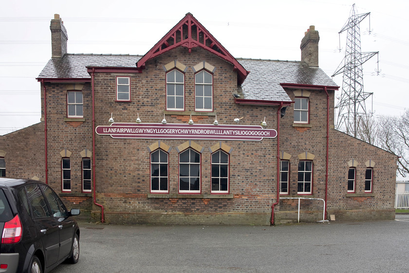 Frontage, Llanfairpwllgwyngyllgogerychwyrndrobwllllantysiligogogoch (Llanfairpwll) station 
 The old station building at Llanfairpwll is now used as a warehouse having no railway use apart from being adorned with the huge reproduction totem carrying its 'other' name Llanfairpwllgwyngyllgogerychwyrndrobwllllantysiligogogoch. This name was a creation of the Victorians and has no histrionical precedent other than to attract visitors in, and, come they do! There is a huge carpark on the site of the old shed and station yard where the coaches of tourists roll in to get their pictures taken with the station signs. They then visit the nearby gift shop to buy their trinkets. 
 Keywords: Frontage Llanfairpwllgwyngyllgogerychwyrndrobwllllantysiligogogoch Llanfairpwll station