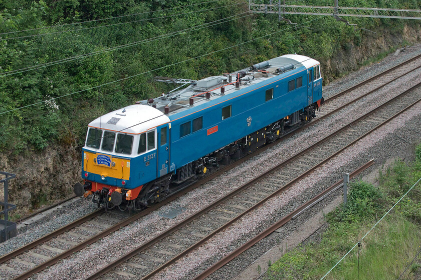 86259, 12.20 Acton Lane Reception sidings-Rugby CS (0Z88, 27L), A508 road bridge 
 86259 'Les Ross/Peter Pan' passes under Roade's A508 road bridge working the 12.20 Acton Lane Reception Sidings to Rugby Carriage Sidings light engine move running as 0X88. It still sports its 'Cumbrian Mountain Express' headboard at the rear following railtour duties yesterday, see.... https://www.ontheupfast.com/p/21936chg/30015949268/x86259-cumbrian-mountain-express 
The locomotive is owned by the esteemed DJ Les Ross who can frequently be seen in the cab during railtours. 
 Keywords: 86259 12.20 Acton Lane Reception sidings-Rugby CS 0Z88 A508 road bridge Les Ross Peter Pan