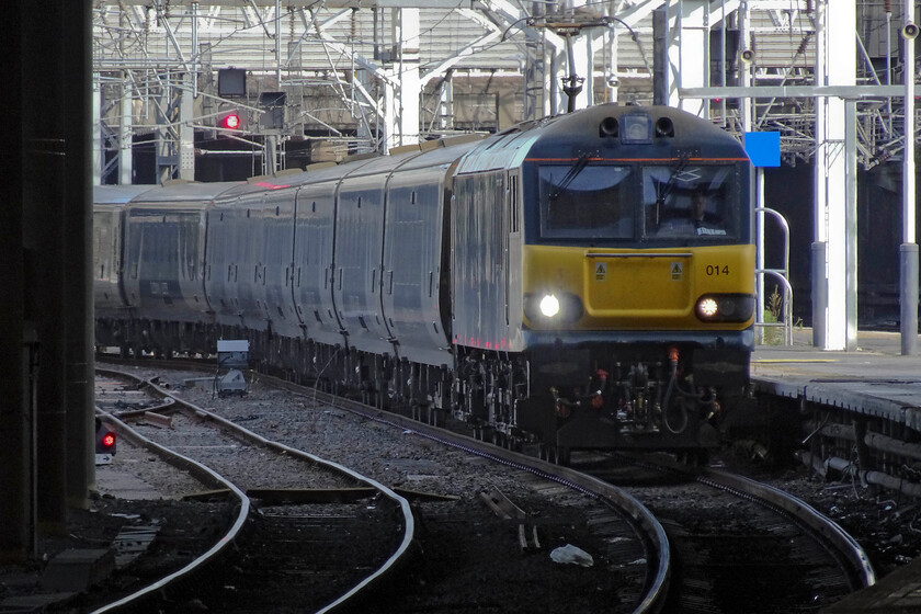 92014, CS 20.45 Inverness, 21.43 Aberdeen & 19.50 Fort William (1M16, 16E), London Euston station 
 As is often the case the sleeper services arrive early as pathing is generous and with the passengers in no rush to exit the train. Led by 92014 the 1M16 Highland service arrives at Euston some sixteen minutes ahead of schedule just catching some morning sunshine. As with the Lowland service that arrived about an hour and a half earlier passengers are allowed to remain in the seat or berths for some time as they come to! I like observing the passengers who do alight on arrival. It's reminiscent of a night flight arrival at an airport but with none of the bother of baggage reclaim, passport control and customs! 
 Keywords: 92014 20.45 Inverness 21.43 Aberdeen 19.50 Fort William 1M16 London Euston station Caledonian Sleeper Highland Sleeper