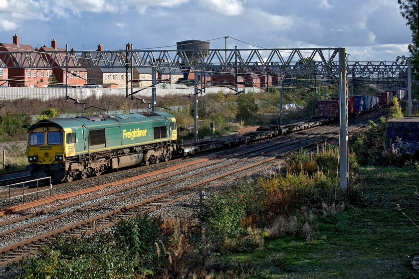 66568, 09.12 Felixstowe North-Trafford Park (4M63, 1L), site of Roade station 
 With the afternoon sunshine getting low in the sky by the end of October the tall trees that line this location at the site of Roade's former station are creating some troublesome shadows that need careful photographic 'dodging'! With 66598 in the sun but with the payload in the shade the ensemble passes working the 4M63 09.12 Felixstowe to Trafford Park Freightliner service. 
 Keywords: 66568 09.12 Felixstowe North-Trafford Park 4M63 site of Roade station Freightliner