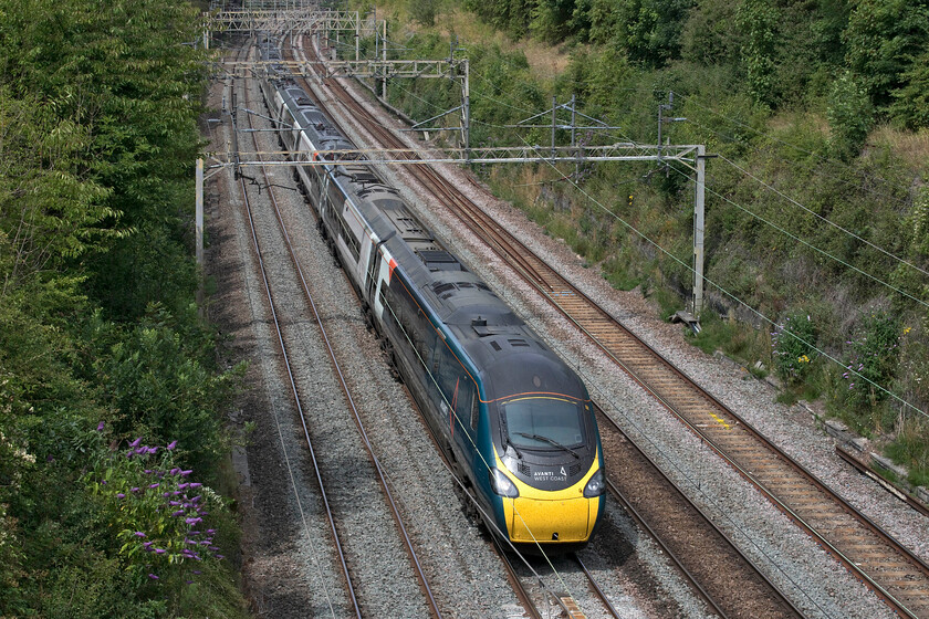 390112, VT 11.55 Manchester Piccadilly-London Euston (1A23, 16L), Hyde Road bridge 
 Eleven coach Pendolino 390112 heads south through Roade cutting about to pass under the villages Hyde Road bridge working the 11.55 Manchester to Euston service. This Pendolino is one of the thirty-one members of the class that were lengthened from nine to eleven coaches, a programme that was undertaken ten years ago in 2012; where has that time gone? 
 Keywords: 390112 11.55 Manchester Piccadilly-London Euston 1A23 Hyde Road bridge Avanti West Coast Pendolino