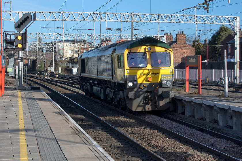 66420, 07.26 Crewe Basford Hall-Peterborough LE, Stafford station 
 On arrival at Stafford and whilst waiting for for my next train to arrive, 66420 trundled southwards through the station. It was forming the 07.26 Crewe Basford Hall to Peterborough light engine move. Unfortunately, I was the wrong side for the sun but with judicious use of Photoshop, a reasonable image has been presented. This is the first picture I have of this particular 2006 loco. in its fresh Freightliner livery. 
 Keywords: 66420 07.26 Crewe Basford Hall-Peterborough Stafford station