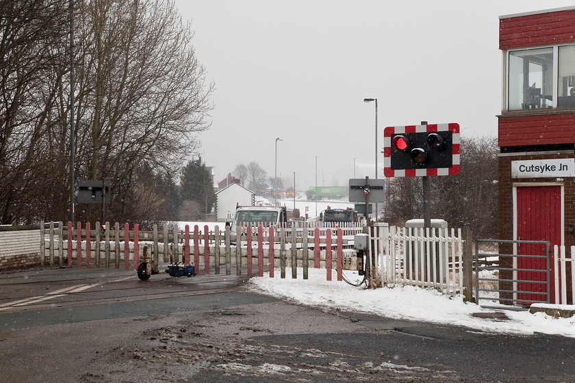 Gates closing, Cutsyke level crossing 
 The electrical wheel boom level crossing gates crossing are in action at Cutsyke closing off the A639 to road traffic. Already there is a fair queue building up on the A639, a busy road to the south of Castleford. Notice that the signal box sign says Cutsyke Junction. There has been no junction here since February 1981 when the Castleford western chord was closed to all traffic, it had been freight-only since 1968. There was also a second station in Castleford situated on this chord called Castleford Cutsyke located on Akerton Road. 
 Keywords: Cutsyke level crossing