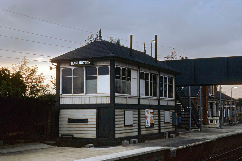 Harlington signal box (Mid, 1913) 
 With last vestiges of the evening light behind the box to the northwest, Harlington signal box is seen. It was located on the down fast platform at the station and is a later Midland Type 2H signal box constructed in 1913. This box is still in use today at the Buckinghamshire Railway Centre at Quainton Road where it is now on a brick base and controls all of their locomotive movements. Notice the extension and raising of the platform underway associated with the electrification of the line that was still some three years away from completion at this time. 
 Keywords: Harlington signal box