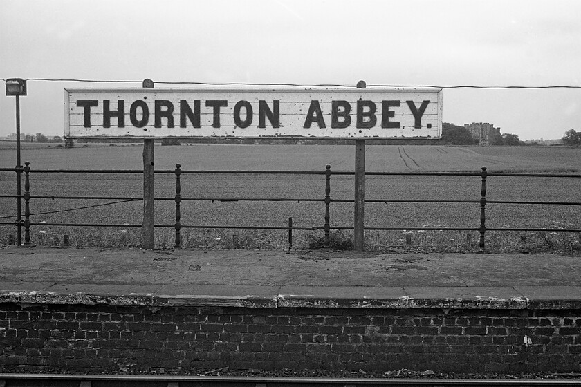 Nameboard, Thornton Abbey station 
 Dating from 1139 Thornton Abbey was constructed at the behest of by William le Gros, the Earl of Yorkshire. As part of Henry XIII's dissolution of monastries, the abbey was turned into a secular college. It later fell into disrepair and was abandoned with all that remains today is the large gatehouse that can be seen to the right of the nameboard in this photograph. The grand wooden nameboard in this view still exists today with an identical view to mine seen here appearing on Wikepedia's page for the station! 
 Keywords: Nameboard Thornton Abbey station