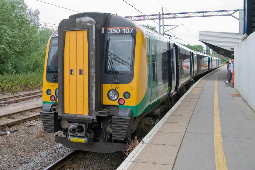 350107, LM 07.54 London Euston-Birmingham New Street (2Y17), Northampton station 
 Our train first train of the day from Northampton to Rugby stands at Northampton station. 350107 is working the 07.54 Euston to Birmingham London Midland service. Notice the boarding to the far right of the image marking the location of the old footbridge that has recently been removed following its repacement as part of the rebuilding of the station. 
 Keywords: 350107 07.54 London Euston-Birmingham New Street 2Y17 Northampton station London Midland Desiro