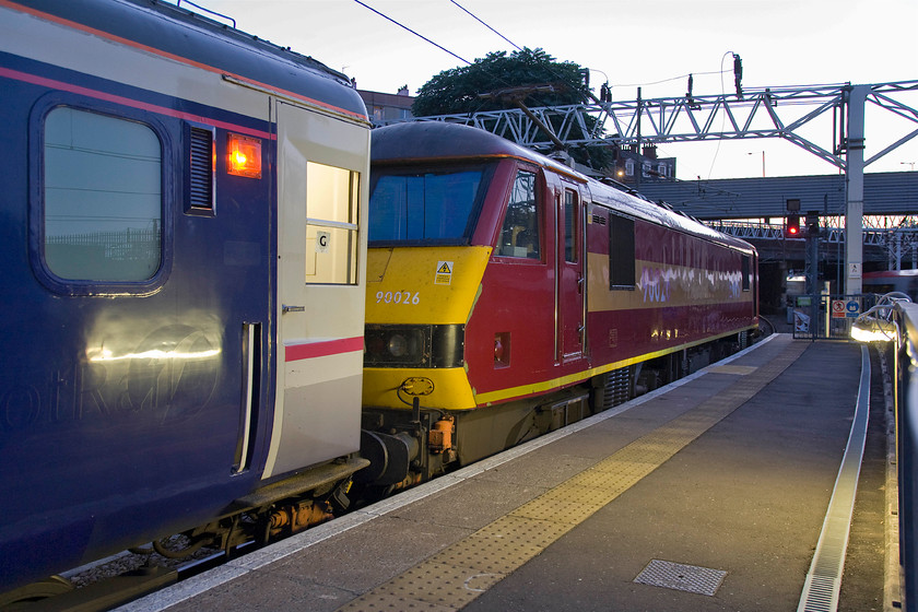 90026, CS 21.16 London Euston-Inverness, Fort William & Aberdeen (1S25), London Euston station 
 It's just before 21.00 with the last vestiges of the day still illuminating the scene at Euston station. 90026 is almost off the end of the very long platform fifteen with the equally long 21.15 sleeper train occupying its entirety. Andy and I would enjoy haulage behind this Class 91 all the way to Scotland with it being detached at Edinburgh Wavelery even though we were in a state of slumber for most of the journey! Notice the evidence of previous operators on the side of the Mk. III sleeper coach in the shape of the First Group logo and the ScotRail wording. 
 Keywords: 90026 21.16 London Euston-Inverness Fort William Aberdeen 1S25 London Euston station Caledonian Sleeper Serco ScotRail