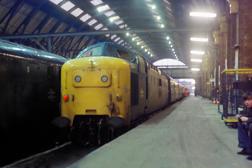 55017, 12.30 Leeds-London Kings Cross (1A21) & 31408, station pilot, London Kings Cross station 
 In the absence of a tripod the long exposure required to take this picture would have presented a problem. I am not sure what I used, but a reasonable image has been recorded of 55017 'The Durham Light Infantry' standing at the blocks at King's Cross. It has arrived with the 12.30 1A21 service from Leeds. This is the second phase of turn 6 whereby 55017 had earlier worked the 1L05 08.15 to Leeds. 31408 stands next to it acting as the station pilot. Notice the once familiar BRUTE trolleys parked on the platform with one being used by one of my companions Guy patiently waiting whilst I take my picture. 
 Keywords: 55017 12.30 Leeds-London Kings Cross 1A21 31408, station pilot London Kings Cross station