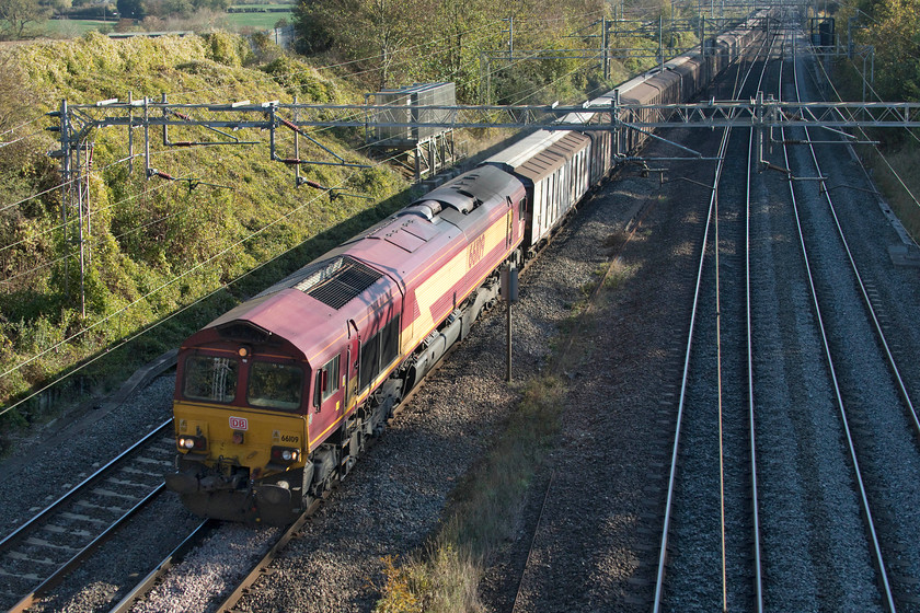 66109, 09.27 Dollands Moor-DIRFT (6M45), Victoria Bridge 
 Still wearing its EWS livery with DB vinyls, 66109 leads the daily 09.27 6M45 Dollands Moor to Daventry railfreight terminal past Victoria Bridge just north of Hanslope Junction. This train conveys ten of thousands of bottles of spring water imported from Europe for onward distribution from Daventry. 
 Keywords: 66109 09.27 Dollands Moor-DIRFT 6M45 Victoria Bridge