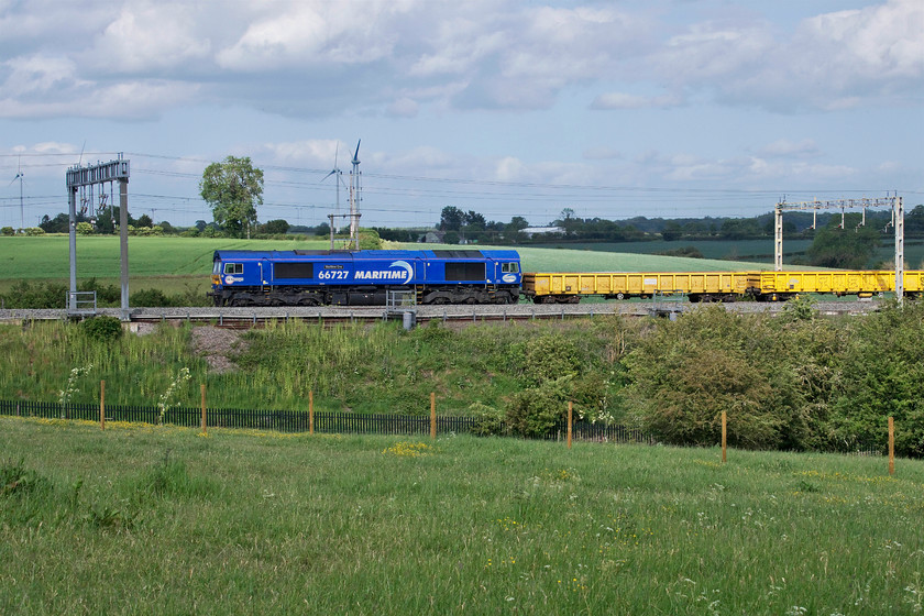 66727, 13.30 Ledburn Junction-Bescot up engineers (6G53, 38L), Roade Hill 
 Within a few minutes of taking the previous photograph, the sun is back out again! 66727 'Maritime One' leads the 13.30 Ledburn Junction to Bescot engineering train past Roade Hill. This had been involved in works taking place just south of Bletchley and is composed of a set of JNA Falcon open ballast wagons probably carrying spent ballast going for recycling back at Bescot. 
 Keywords: 66727 13.30 Ledburn Junction-Bescot up engineers 6G53 Roade Hill Maritime One