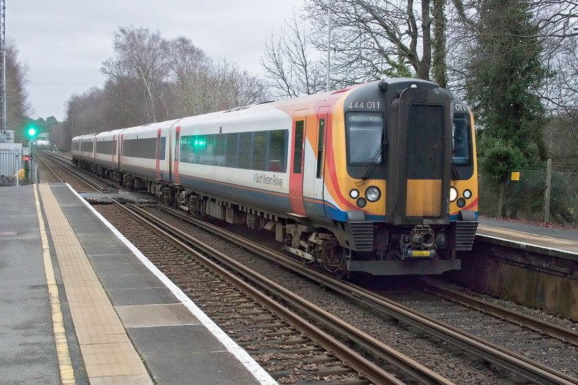 444011, SW 09.35 London Waterloo-Weymouth (1W19, 32L), Holton Heath station 
 It is just after midday but it is ridiculously overcast and dull. Witness the strong reflection of the up colour light on the side of 444011. The unit is passing through Holton Heath station forming the 09.35 Waterloo to Weymouth service. Holton Heath station opened relatively late in 1924 and was built to serve the huge and strategically important Royal Navy cordite works. This site had a comprehensive network of tracks that connected to a short branch that led down to Rockley Jetty in Poole Harbour. Here the cordite was sent by coaster to Gosport. The plant was closed by the RN just after World War II with most of the site now occupied by the Holton Heath industrial estate but with plenty of evidence of its former life next to the station. 
 Keywords: 444011 09.35 London Waterloo-Weymouth 1W19 Holton Heath station SWR London South Western Railway