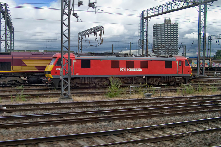 Class 66 & 90029, stabled, Willesden yard 
 Passing Wembley yard found an unidentified Class 66 hiding behind 90029. Both locomotives are stabled in the yard awaiting their next turn of duty. 
 Keywords: Class 66 90029 Willesden yard