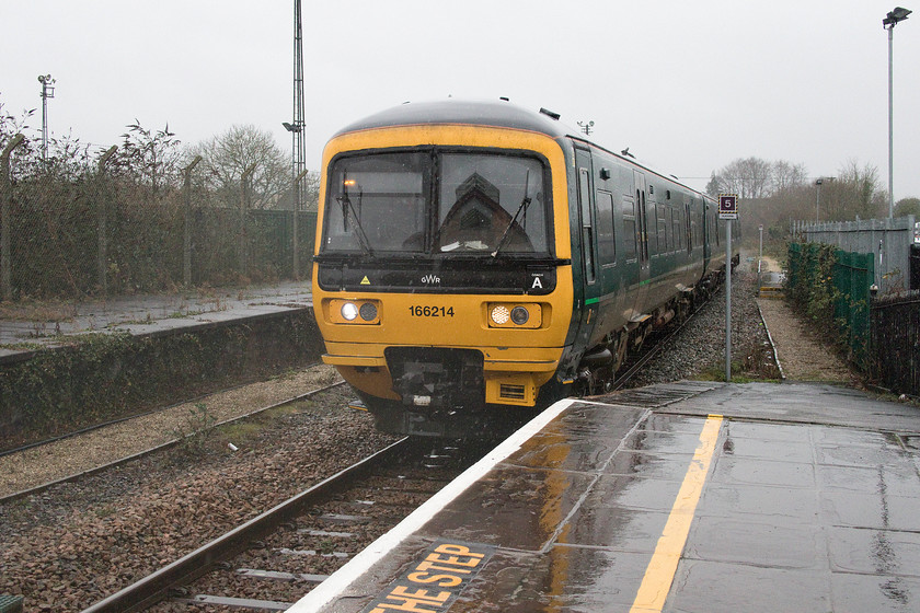 166214, GW 08.52 Weymouth-Gloucester (2V88, RT), Frome station 
 In torrential rain and swirling wind, 166214 arrives at Frome station working the 08.52 Weymouth to Gloucester 2V88 service. My wife and I took this train as far as Bristol Temple Meads as the first leg of or journey home to Milton Keynes. Out of use for decades, the former down platform at Frome station is still extant, seen to the left of this image. 
 Keywords: 166214 08.52 Weymouth-Gloucester 2V88 From station Turbo Great Western Railway