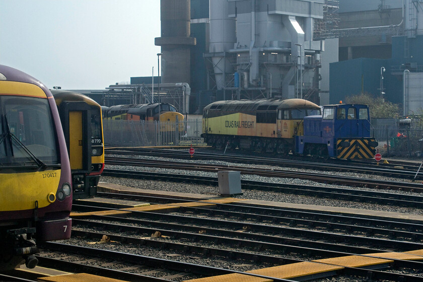 170417, 158770, 37254, 56087 & No.11, stabled, Nottingham Eastcroft 
 Nottingham's Eastcroft depot has become a busy place in recent years. Indeed, from passing trains, there is too much to try and record on a pad without the use of some sort of electronic aid! Andy was grateful for my camera and my extra pair of eyes as he is far more of a number collector than I am! In this view, two versions of the same TOCs liveries are represented on the extreme left with EMR's 170417 and 158770 seen. In the middle distance stabled at Colas' facility are 37254 'Cardiff Canton' and 56087 with their resident shunter No. 11 attached to the front of the Grid. 
 Keywords: 170417 158770 37254 56087 No.11stabled Nottingham Eastcroft Colas Cardiff Canton