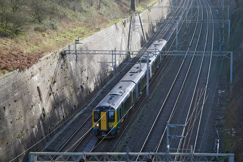 350108, LM 11.49 London Euston-Birmingham New Street (1W11), Roade cutting 
 350108 heads north through Roade cutting working London Midland's 11.49 Euston to Birmingham New Street. It's half-past twelve and already the sun has all but gone from the depths of the cutting but it is just over a week off from the shortest day. With the days now gaining just under a minute of light per day, it won't be long until normal service is resumed and the clocks will be moved forward! 
 Keywords: 350108 LM 11.49 London Euston-Birmingham New Street 1W11 Roade cutting London Midland Desiro