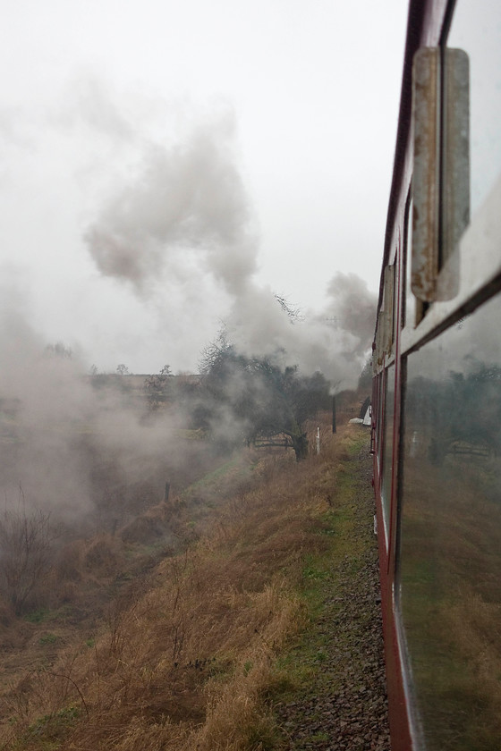 2104, 12.00 Pitsford & Brampton return, crossing Bridge 13 
 Peckett 0-4-0 2104 works hard through the rain hauling the 12.00 Pitsford and Brampton Mince Pie Special return working. It is seen near to the fabled Bridge 13 that cost the NLR so dear when extending their line northwards. 
 Keywords: 2104 Bridge 13 Northampton and Lamport Railway