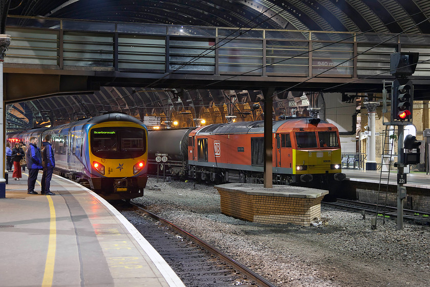 185146, unidentified Scarborough working & 60039, 18.47 Jarrow-Lindsey oil refinery (6D43), York station 
 This was a picture that, once again, pushed the camera to the limits of its operation! 60039 'Dove Holes', leading the 6D43 18.47 Jarrow to Lindsey oil train, did not stop at York station but it had slowed to a walking pace meaning a picture was just possible. Using a shutter speed of 1/10 sec. enabled the train to be captured with just a hint of motion blur, there is actually more in the lady walking by the side of 185146! If I had waited until the train had cleared the footbridge and composed a better picture, it would have been hopelessly blurred as it was picking up speed rapidly. I really like the challenges of taking pictures after dark and also like the completely different mood that can be created in an image. 
 Keywords: 185146 Scarborough working 60039 18.47 Jarrow-Lindsey oil refinery 6D43 York station