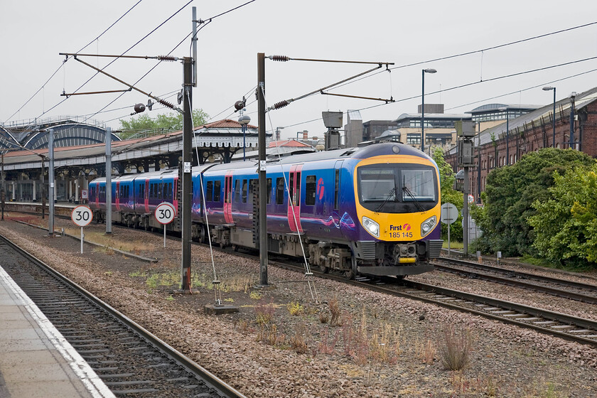 185145, TP 08.28 Middlesborough-Manchester Airport (1P23), York station 
 185145 storms away from work station working the 08.28 Middlesborough to Manchester Airport TPE service. These units are powerful and are blessed with excellent acceleration that is useful on turns with a lot of stops. However, when driven with a little spirit their fuel consumption is very poor. Indeed, TPE has introduced an enhanced driver training programme aimed to encourage staff to operate them in a more economical manner in an effort to reduce fuel costs. 
 Keywords: 185145 08.28 Middlesborough-Manchester Airport 1P23 York station TransPennine Express