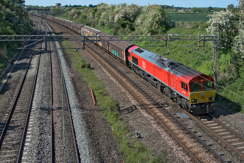 66124, 14.47 DIRFT-Dollands Moor (6M45, 4E), Victoria bridge 
 Despite being twenty-one years old the bright red DB livery applied to 66124 looks smart and keeps it looking relatively modern. It is seen leading the 14.47 Daventry to Dollands Moor empty bottled water train that will continue its journey overnight through the tunnel and to the continent. 
 Keywords: 66124 14.47 DIRFT-Dollands Moor 6M45 Victoria bridge