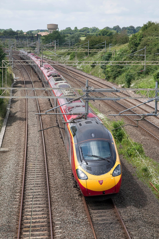 390045, VT 13.30 Birmingham New Street-London Euston (1B29), Victoria bridge 
 390045 '101 Squadron.' passes Victoria bridge just south of Roade forming the 13.30 Birmingham New Street to London Euston. Notice the huge mountain of crushed concrete that has grown up next to the water tower. This is from the structures of the old Pianofort factory site that has been demolished to make way for a huge house estate. 
 Keywords: 390045 13.30 Birmingham New Street-London Euston 1B29 Victoria bridge