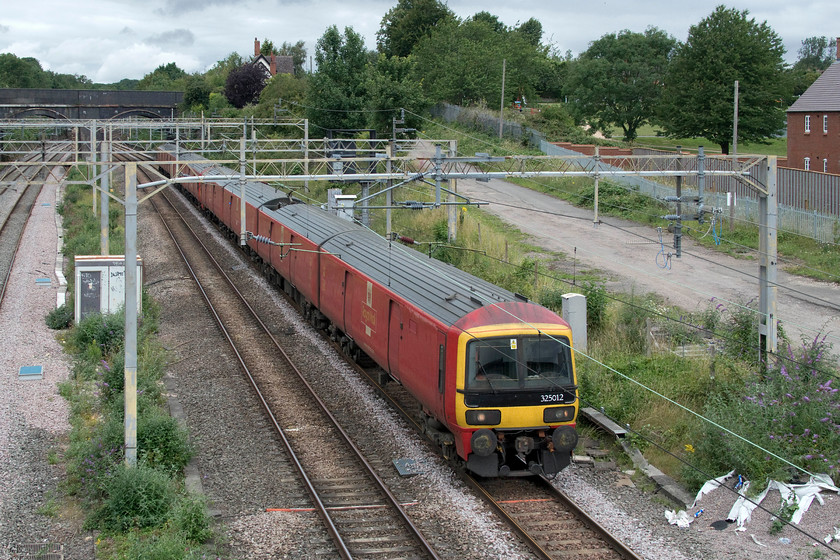 325012 & 325001, 11.20 Crewe TMD-Willesden PRDC (5A91, 4L), site of Roade station 
 Hot on the heels of the Class 720 mileage accumulation run was the daily empty postal vans heading south to Willesden Royal Mail depot in preparation for the evening's down loaded mail trains. 325012 and 325001 pass the site of Roade station as the 5A91 11.20 Crewe TMD to Willesden. After the demise of the mobile sorting office mail trains in 2002, there is further talk of them returning again in an effort to get more lorries off the roads and to reduce CO2 emissions. 
 Keywords: 325012 325001 11.20 Crewe TMD-Willesden PRDC 5A91 site of Roade station Royal Mail