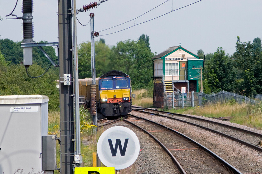 66304, 13.42 Mountsorrel-Crewe Basford Hall (6U77), Lichfield Trent Valley Junction (from Lichfield Trent Valley High Level station) 
 Having taken the short absolute block section of track from Alrewas to here ar Lichfield Trent Valley Junction the 13.42 Mountsorrel to Crewe Basford Hall stone train takes the short spur to the north so that it can join the WCML. DRS' 66304 leads the train as it gingerly takes the sharp curve on to the single track spur. I am standing on the platform end of Trent Valley High Level station in order to take this unusual view including the superb L&NWR 1897 signal box. 
 Keywords: 66304 13.42 Mountsorrel-Crewe Basford Hall 6U77 Lichfield Trent Valley Junction