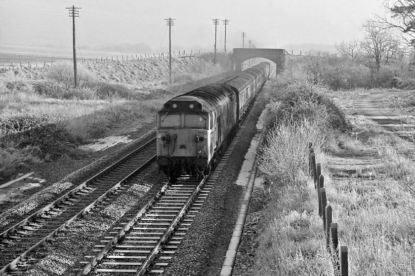 50019, unidentified down working, site of Patney & Chirton station SU070591 
 With the frost hanging heavily on the trees and grass, 50019 'Ramillies' shatters the winter's peace in deepest Wiltshire. It is passing the site of the old Patney and Chirton station, which shut on 18.06.66, with an unidentified down working for the West Country. Looking at Google Earth reveals that this scene is very similar today including the old station footbridge that the picture is taken from. Also still with us is 50019 which is based on the Mid Norfolk Railway and still seeing regular use. 
 Keywords: 50019 down working site of Patney & Chirton station SU070591