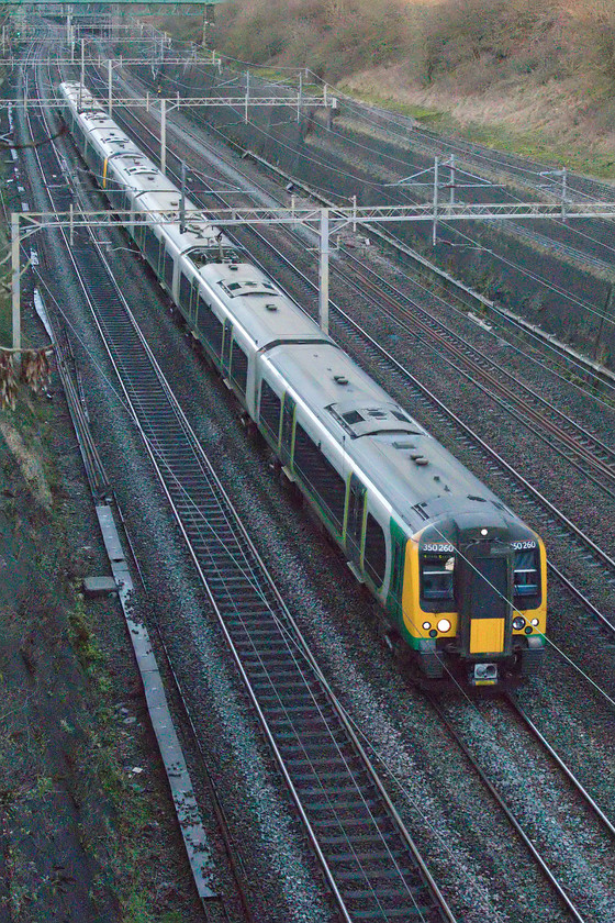 350260 & 350248, LN 13.33 Crewe-London Euston (1U32, 1L), Roade cutting 
 London Northwestern's 350260 and 350248 pass through Roade cutting on the eponymous up fast forming the 13.33 Crewe to Euston service. I had to really ramp up the ISO on the camera to secure this image that took a considerable amount of work in Photoshop to sort out the not inconsiderable amount of digital noise (or digital grain). 
 Keywords: 350260 350248 13.33 Crewe-London Euston 1U32 Roade cutting London Northwestern Desiro