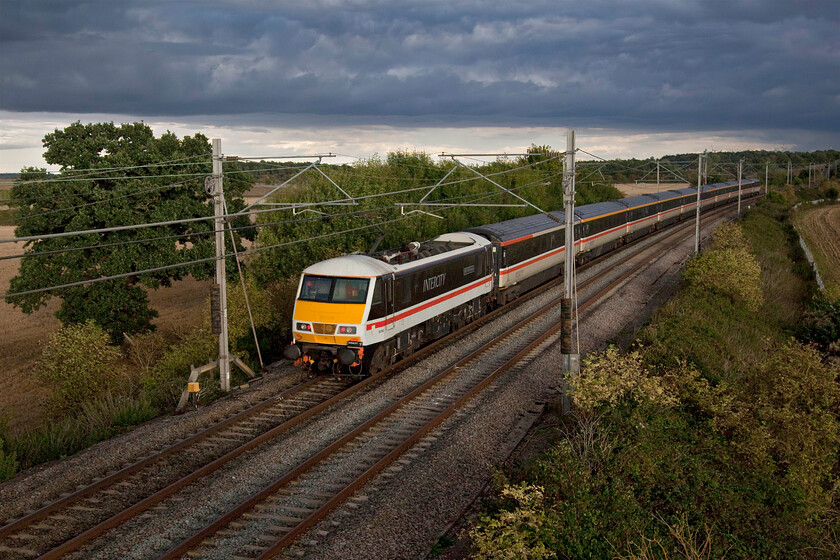 90002 & 82139, 16.02 Manchester Piccadilly-London Euston (1Z96, 11L), Blisworth 
 I deliberately chose to frame the photograph with the train slightly off-centre so as to include the rather nice tree with its leaves still in full colour to the left that just so happened to be against the lighter portion of an otherwise dark and ominous looking sky. 90012 'Wolf of Badenoch' is seen propelling the rear of the 1Z96 16.02 Manchester to Euston LSL relief service. This was a Sunday evening and was the final few hours (until 06.30 the next morning) of the Queen's lying in state in Westminster Hall. The train may well have been carrying mourners eager to join the huge overnight queue as some of the last to file past. The return service in the early evening will probably have been carrying mourners home and away from London having paid their respects. 
 Keywords: 90002 82139 16.02 Manchester Piccadilly-London Euston 1Z96 Blisworth Wolf of Badenoch