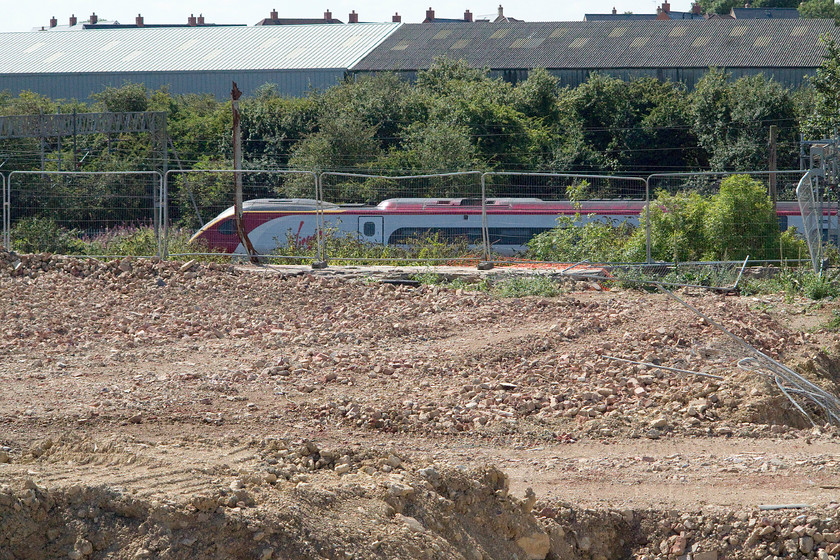 Class 390, VT 12.30 London Euston-Glasgow Central (1S63), Pianoforte site 
 Not a shot that I would normally take but it was for a particular purpose. As can be seen from the foreground, the old Pianoforte site in Roade has been flattened, a task that took two years due to higher than expected levels of polluted ground that needed dealing with. Soon, this land will morph into a huge housing development thus blocking any view of the line from this position. Incidentally, this housing development has not been welcomed by many in the village of Roade, including us, as it will impinge on our view (Bloody NIMDYs!) 
 Keywords: Class 390 12.30 London Euston-Glasgow Central 1S63 Pianoforte site