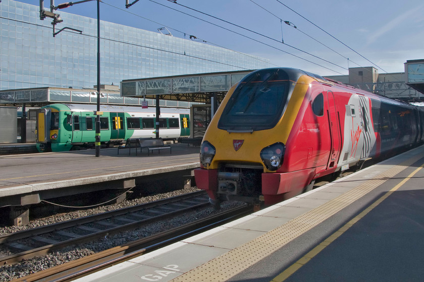 377703, SN 12.13 Milton Keynes Central-South Croydon (2O39) & 221115, VT 08.55 Holyhead-London Euston (1A25), Milton Keynes Central station 
 Southern meets Virgin at Milton Keynes Central. To the left, 377703 sits at platform two with the 12.13 to South Croydon. Meanwhile, 221115 'Polmadie Depot' pauses at platform five with the 1A25 08.55 Holyhead to Euston. 
 Keywords: 377703 12.13 Milton Keynes Central-South Croydon 2O39 221115 08.55 Holyhead-London Euston 1A25 Milton Keynes Central station