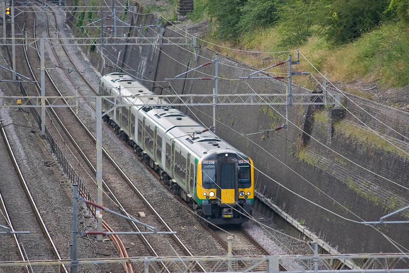 350236, LM 17.54 Birmingham New Street-London Euston (2Y96), Roade cutting 
 350236 works the 17.54 Birmingham New Street to Euston 2Y96 'all stations' service passes south through Roade cutting. It is being worked by one of the second batch of Class 350 Desiros introduced during 2008 and 2009 ostensively to enable the new Crewe to Euston services running via Stoke-on-Trent and stopping at most of the Trent Valley Line stations. 
 Keywords: 350236 17.54 Birmingham New Street-London Euston 2Y96 Roade cutting London Midland Desiro