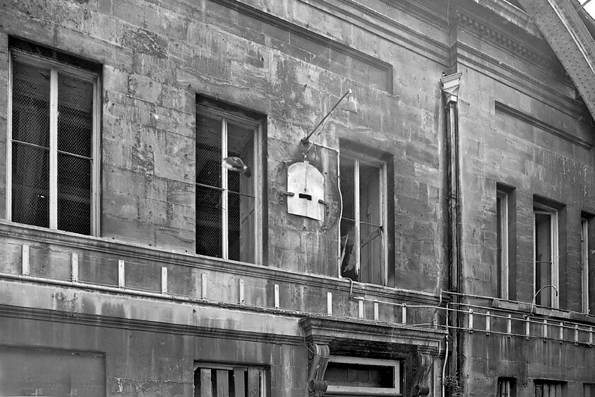 Main building from concourse, Bath Green Park station 
 The grand stone main building at Bath Green Park station was an elegant mock Georgian structure both from the outside and from this view showing the inside. The station buildings were designed by the Midland Railway architect John Holloway Sanders who was responsible for many of the companies' stations and structures stretching from the Scottish Borders to here in Somerset (or the County of Avon as it was back in 1981) that must be about far south as the company operated? The white board in the middle of the photograph with an angled lamp to illuminate it once mounted the large station clock the outline shape of which can still be decerned; one can only wonder where that ended up! Close examination of this image reveals a pigeon in full flight in front of the first floor second window from the left. 
 Keywords: Main building from concourse Bath Green Park station