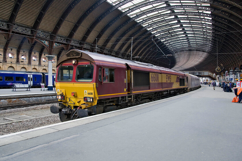 66011, 09.53 Redcar BSC-Rylstone, York station 
 66011 takes the sharp curve into York's platform three at York leading the 09.53 BSC Redcar to Rylstone empty stone train. The train came to a halt in order to facilitate a crew change with the relief driver getting his belongings together to the extreme right of the photograph. 
 Keywords: 66011 09.53 Redcar BSC-Rylstone York station EWS