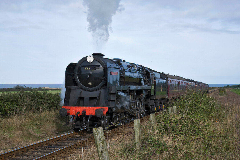 92203, 12.00 Sheringham-Holt, Weybourne TG122424 
 92203 'Black Prince' approaches Weybourne leading the 12.00 Sheringham to Holt NNR service. With images that can include such things as the sea in the background and the remnants of the vintage fence in the foreground, this heritage line offers some perfect photographic opportunities for the railway photgrapher. 
 Keywords: 92203 12.00 Sheringham-Holt Weybourne TG122424