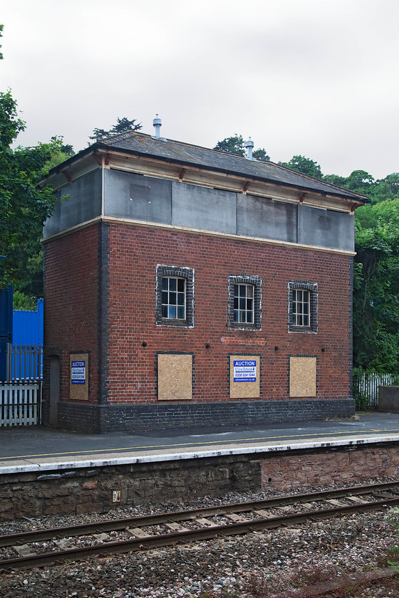 Torre signal box (disused) (GW, 1921) 
 Torre signal box looks a sad sight all boarded up on the up platform at the station. It has been used for various things since it closed in November 1984 but, as can be seen from the notice, it is due to go to auction later in the year. The box is a grade II listed structure built by the Great Western in 1921. I presume that its height was to facilitate sighting but, it certainly gives options to a purchaser! A picture of it in happier times can be found at..... https://www.ontheupfast.com/p/21936chg/29500835204/x8-torre-signal-box-gw-1921 
 Keywords: Torre signal box