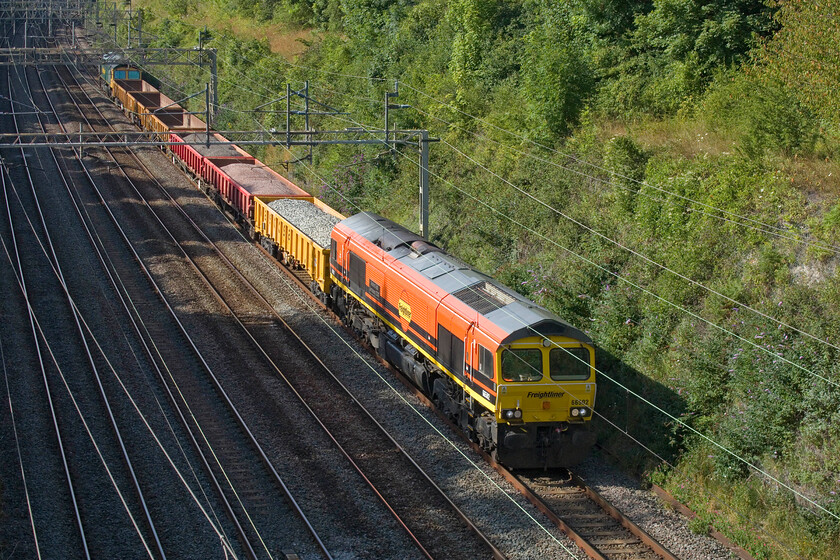 66502 & 66548, 15.44 Bescot Yard-Camden Junction (6Y66, 9E), Hyde Road bridge 
 66502 'Basford Hall Centenary 2001' leads an unusually short half-loaded infrastructure working through Roade cutting taken from Hyde Roade bridge. At the rear of the 6Y66 15.44 Bescot Yard to Camden Junction is 66548. After a very dull start to the day the afternoon has turned into a bright and sunny one as can be seen here making a pleasant change! 
 Keywords: 66502 66548 15.44 Bescot Yard-Camden Junction 6Y66 Hyde Road bridge Freightliner Basford Hall Centenary 2001