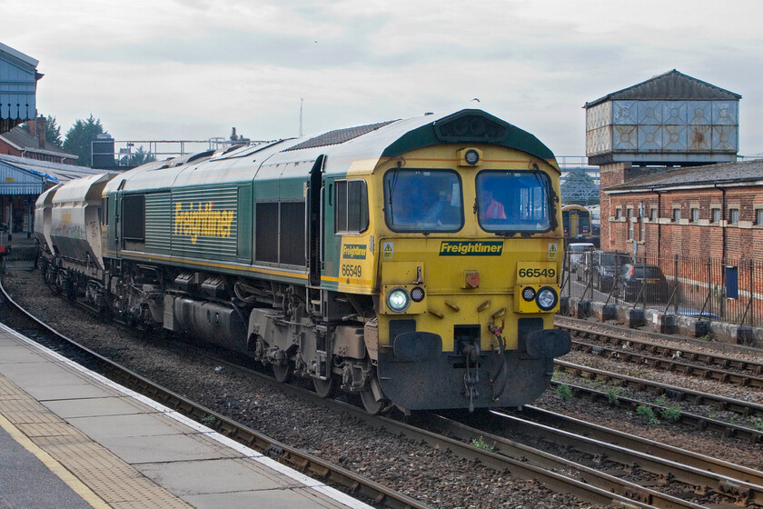 66549, 12.45 Theale Lafarge-Wool Sidings (6O49), Salisbury station 
 With a cre change having taken place on the platform 66549 gets the 6O49 12.45 Theale Lafarge to Wool Sidings empty snad train under way. This is a popular working in the south that is often devoid of freight apart from Freightliner workings to and from Southampton. Notice the large former water tower in the background. 
 Keywords: 66549 12.45 Theale Lafarge-Wool Sidings 6O49 Salisbury station Freightliner sand train