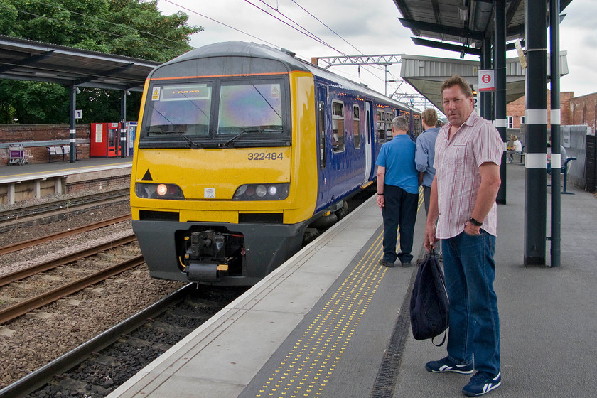 Trevor & 322484, NT 11.26 Doncaster-Leeds (2B14), Wakefield Westgate station 
 My boss gazes at me not quite able to understand my interest in railways and my obsession to take pictures, despite me trying to explain it to him several times! He stands on Wakefield Westgate station as our next train for our Northampton to Knaresborough journey arrives. Northern Rail's 322484, working the 11.26 Doncaster to Leeds that we took to the end of its journey. 
 Keywords: Trevor 322484 11.26 Doncaster-Leeds 2B14 Wakefield Westgate station Northern Rail