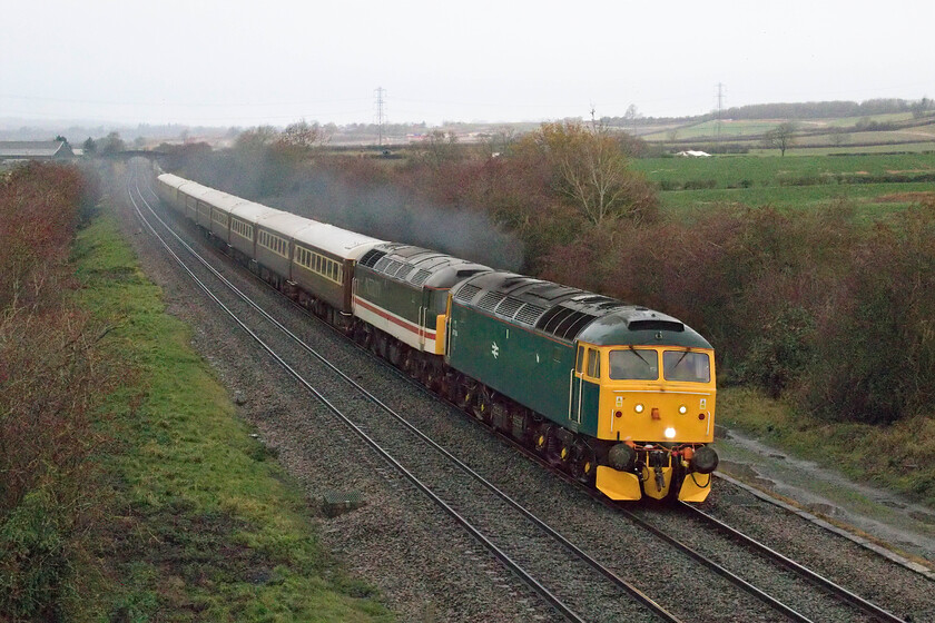 47614 & 47828, outward leg of The Salisbury & Bath Christmas Statesman, 06.17 Chesterfield-Bath Spa (1Z70, 8L), Braybrooke SP769849 
 In absolutely dreadful lighting and with sleet beginning to fall again the 1Z70 06.17 Chesterfield to Bath via London Salisbury Statesman Rail charter passes Braybrooke between Market Harborough and Kettering. 47614 and 47828 lead the train that did not appear to very busy with punters who could expect to pay up to 210 for a ticket! Unfortunately, like a number of charters that were planned to visit Bath this year for its renowned Christmas market plans had to be changed with the announcement that the market would not run again this year, see.... https://www.itv.com/news/westcountry/2021-10-11/bath-christmas-market-2021-cancellation-devastating-blow I suspect that many passengers aboard the charter would opt to leave the train at Salisbury instead of continuing on towards Bath. 
 Keywords: 47614 47828 The Salisbury & Bath Christmas Statesman 06.17 Chesterfield-Bath Spa 1Z70 Braybrooke SP769849 Class 47 Statesman Rail