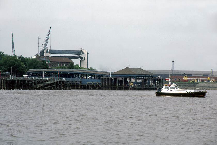 Hull Corporation Pier from MV Farringford 
 As MV Farringford approaches Hull Corporation Pier with the 16.50 sailing from New Holland the landmarks of Kingston-upon-Hull come into view. In this photograph, the most prominent landmark is the tidal surge barrier that was opened the previous year in 1980. It was designed and constructed to prevent the high tides of the Humber estuary from flowing back up the River Hull effectively impounding it. In the foreground is Hull's Corporation pier with its floating pontoon covered by an attractive hipped roof. 
 Keywords: Hull Corporation Pier from MV Farringford Sealink